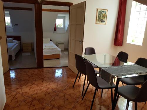 a dining room with a table and chairs and a bedroom at Böne Vendégház és Borozó in Tokaj