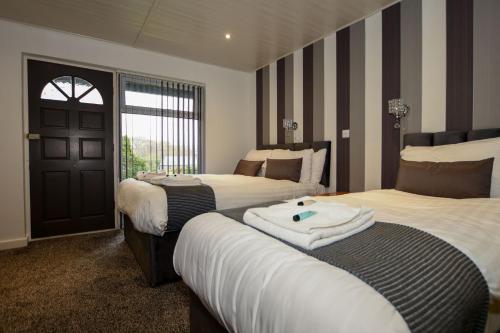 a hotel room with two beds and a door at Conwy Valley Hotel in Conwy