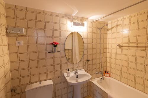 uma casa de banho com um lavatório, um WC e um espelho. em Huegas - A 90 metros del Reloj de Formigal em Formigal