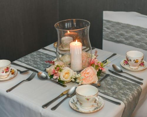 a table with a candle and plates and cups and spoons at Conwy Valley Hotel in Conwy