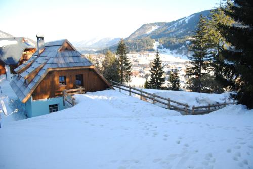 a cabin in the snow with footprints in the snow at La Lince Lodge in Camporosso in Valcanale