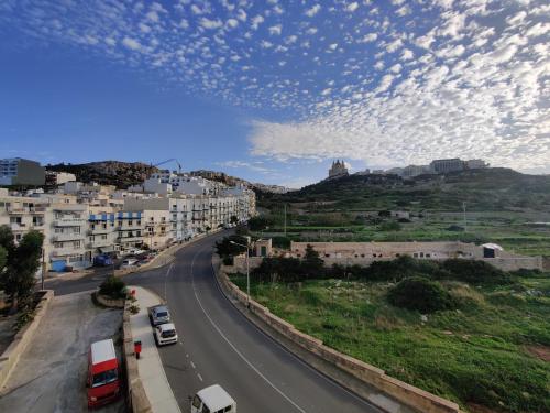 een uitzicht op een straat met bewolkte lucht bij Mellieha Seaside Apartment in Mellieħa