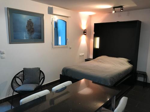 a bedroom with a bed and a table and chairs at Studio Le sillon malouin vue mer in Saint Malo