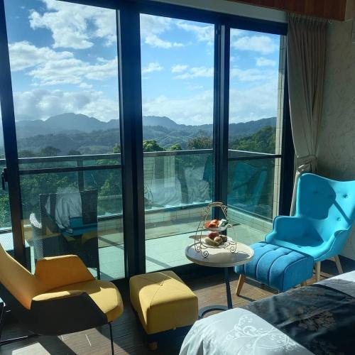 a bedroom with a large window with a view of the mountains at 山水奇異San Shuei Kiwi桃園市民宿編號038 Homestay in Sanmin