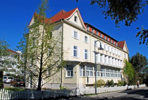 ein großes weißes Gebäude mit rotem Dach in der Unterkunft Ferienwohnung mit Balkon "Charming Holidays" in Binz