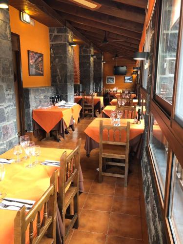 a restaurant with tables and chairs in a room at Hotel Sarao in Escarrilla
