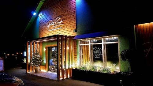 a store front at night with a christmas tree in the window at Pebble Beach Seaview Restaurant & Rooms in Milton