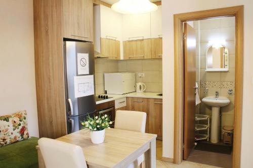 a small kitchen with a table and a refrigerator at Apartments Paradisos in Kragujevac