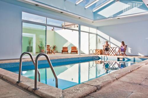 uma casa com piscina com pessoas ao fundo em Quintana Hotel em San Luis