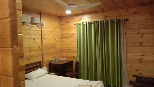 a bedroom with a bed and a green curtain at Kashid Heritage Beach Resort in Kashid