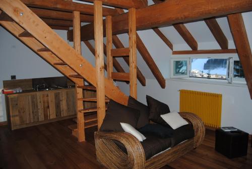a living room with a couch and a wooden stairs at La Lince Lodge in Camporosso in Valcanale