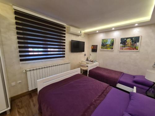 a bedroom with two beds and a sink and a window at Hotel Sunce in Kraljevo