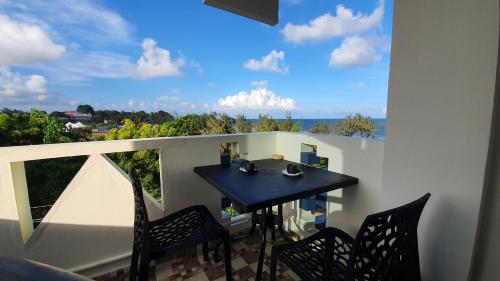 a balcony with a black table and chairs and a window at Little Island (Beach Cafe & Guest House) in Mahabalipuram