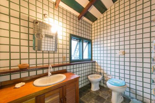 um banheiro com pia e vaso sanitário em Búzios Samba Suítes em Búzios