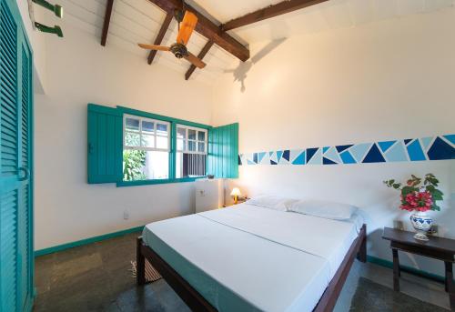 um quarto com uma cama e uma janela em Búzios Samba Suítes em Búzios