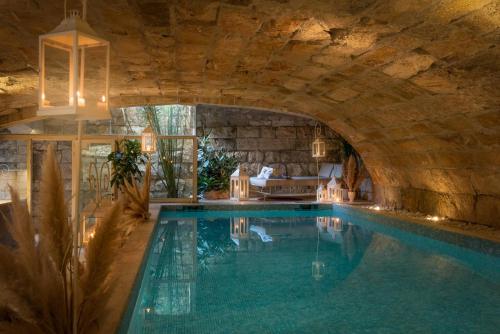 an indoor swimming pool with a stone wall and a ceiling at Villa Galatea in San Vincenzo