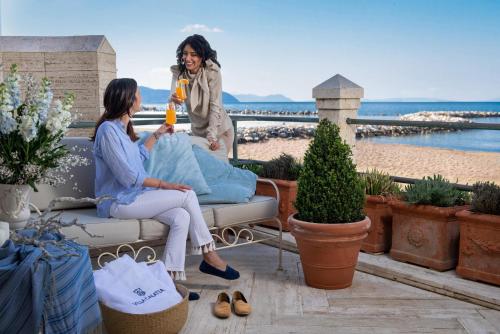 two women sitting on a couch on a patio at Villa Galatea in San Vincenzo