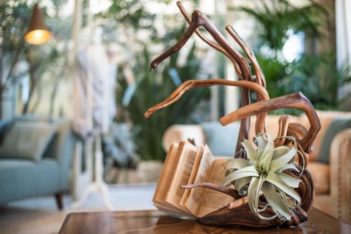 a book holder on a table with a flower in it at Villa Galatea in San Vincenzo