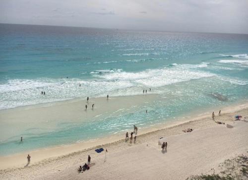 a group of people on a beach near the ocean at Studio oceanfront prime location in Cancún