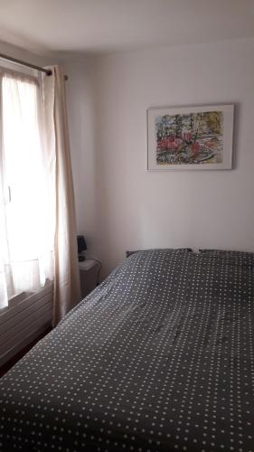 a bedroom with a bed and a window at Appartement cosy dans le centre historique in Saint-Germain-en-Laye