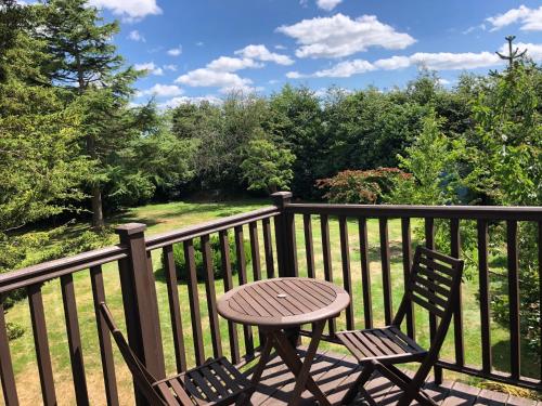 a wooden table and two chairs on a balcony at The Garden Loft in Freethorpe