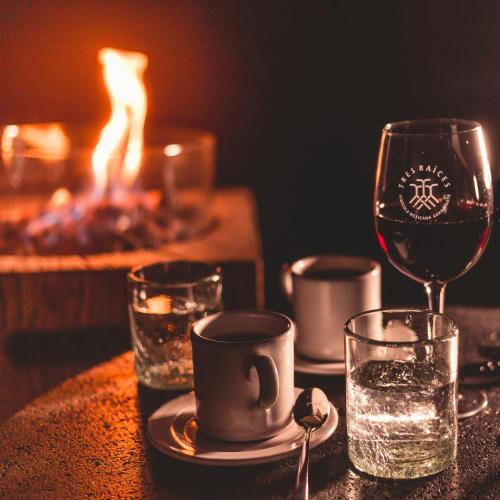 a table with a cup and a glass of wine at Casa Raíces Hotel Luxury & Viñedo in Los Galvanes