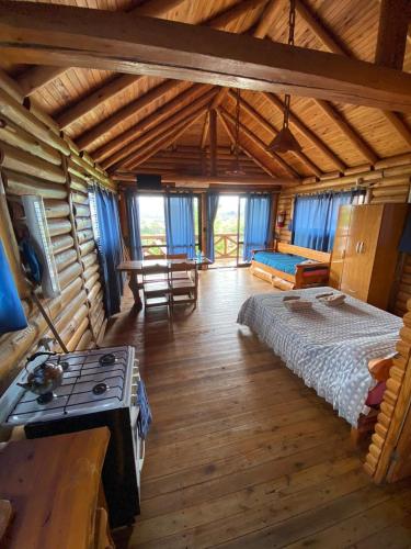 a bedroom in a log cabin with a bed and a stove at Cabañas Los Álamos in Villa Carlos Paz