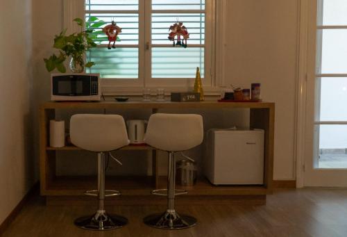 a kitchen with a counter with two stools and a microwave at Habitación en La Casa de Mis Padres in Mendoza