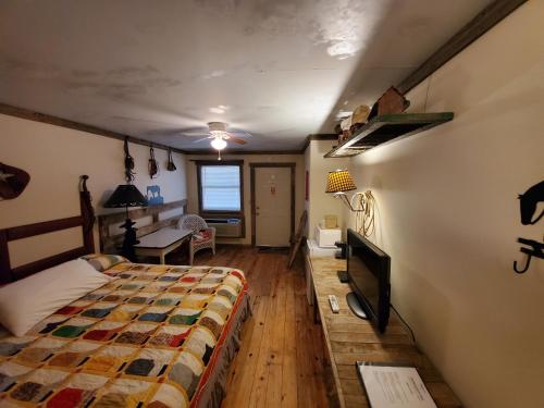 a bedroom with a bed and a tv on a wall at Jamesport Inn in Jamesport