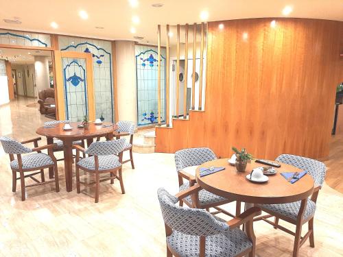 a waiting room with tables and chairs and stained glass windows at Hotel Nueva Plaza in Maliaño