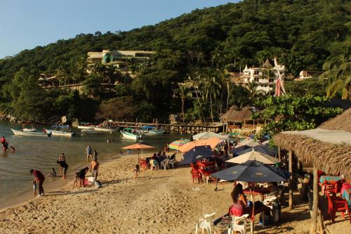 a group of people on a beach with umbrellas at La Posada Pacifica in Puerto Vallarta