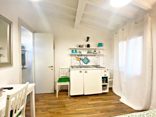 フィレンツェにあるSanto Spirito Suiteの白いキャビネットとテーブル付きのキッチン