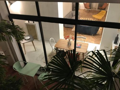 a table and chairs in a room with a view of a living room at Maison Caju - La Rochelle in La Rochelle