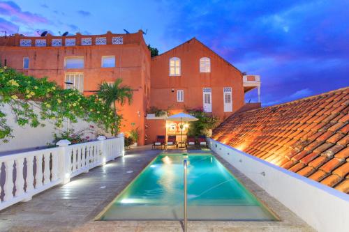 una casa con piscina frente a un edificio en Hotel Boutique Casa del Coliseo, en Cartagena de Indias