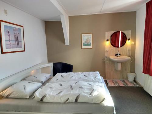 ein Schlafzimmer mit einem weißen Bett und einem Waschbecken in der Unterkunft APARTMENT BY THE SEA Bed by the Sea in Vlissingen