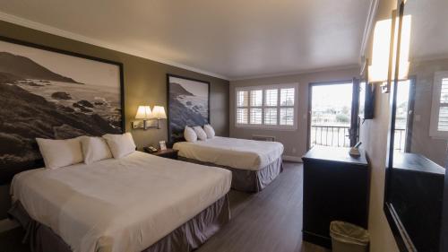 a hotel room with two beds and a balcony at Super 8 by Wyndham Santa Cruz/Beach Boardwalk East in Santa Cruz