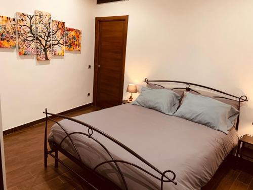- une chambre avec un lit et deux peintures murales dans l'établissement Il Torrione, à Ceccano