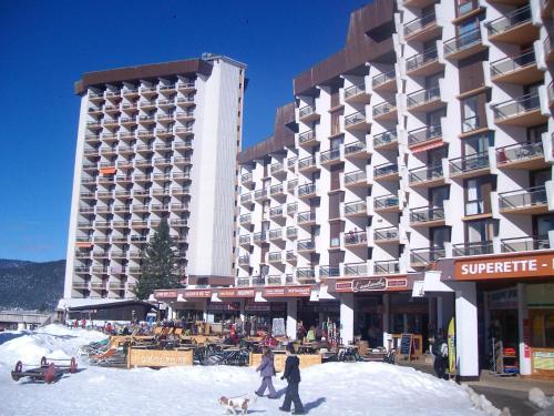 a group of people walking in the snow in front of a hotel at La Grande Moucherolle bis in Villard-de-Lans