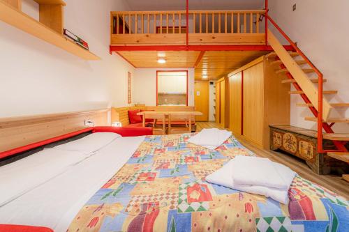 a bedroom with a large bed with a staircase at Dolomites Dream Marmolada in Rocca Pietore