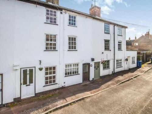 a white building on the side of a street at Agniti Cottage in Derby