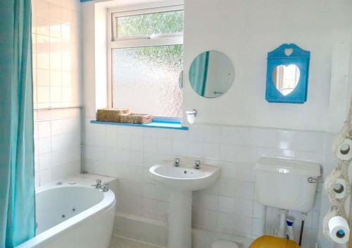 a bathroom with a tub and a sink and a toilet at Healing Waters Sanctuary for Exclusive Private Hire and Self Catering Board, Vegetarian, Alcohol & Wifi Free Retreat in Glastonbury in Glastonbury