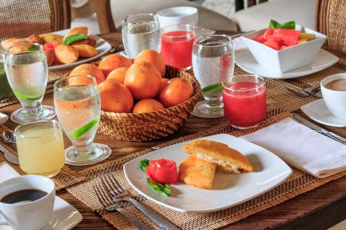 a wooden table topped with plates of food and drinks at Hotel Boutique Casa del Coliseo in Cartagena de Indias