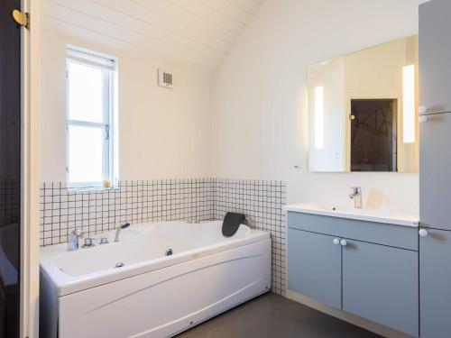 uma casa de banho branca com uma banheira e um lavatório em Holiday home Hvide Sande LXI em Hvide Sande