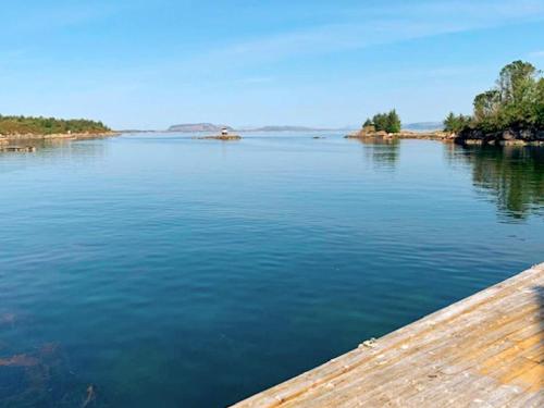 a view of a river with a wooden pier at 6 person holiday home in Austrheim in Utkeila