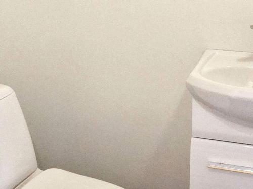 a bathroom with a white toilet and a sink at 6 person holiday home in Austrheim in Utkeila