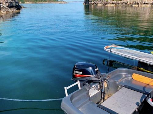 a boat is tied up to the dock on the water at 6 person holiday home in Austrheim in Utkeila