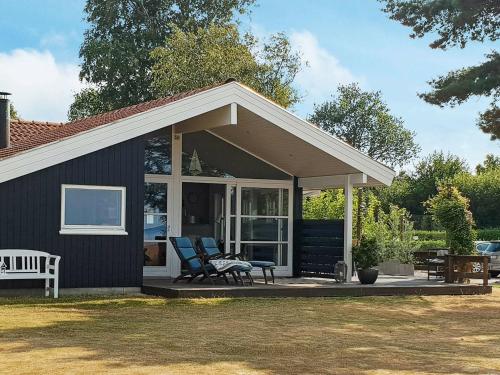 ノーポにある6 person holiday home in Nordborgの小屋(ポーチ、椅子2脚付)