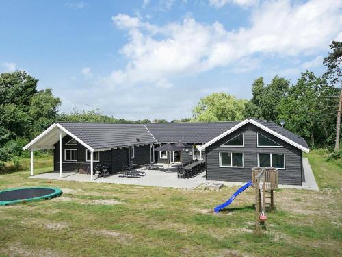 een huis met een speeltuin ervoor bij 22 person holiday home in Nex in Bedegård