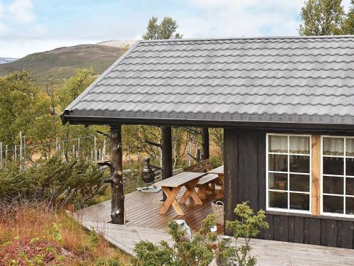 a cabin with a picnic table on a deck at 6 person holiday home in Rennebu in Sundset