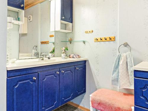 a blue bathroom with a sink and a mirror at Seaside Fisherman s Haven-By Traum in Steinsbø